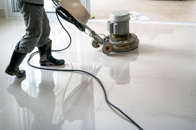 Photo of a man cleaning the floor with a cleaning machine.